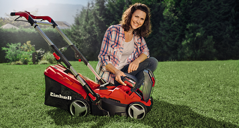 woman with einhell cordless lawn mower