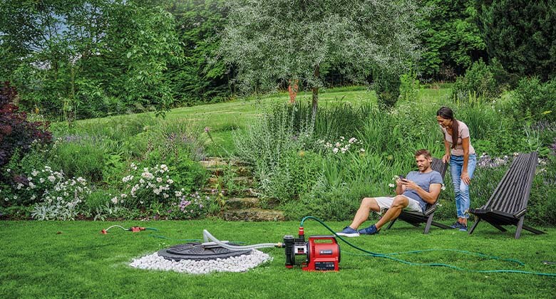 man and woman using einhell water pump in a garden